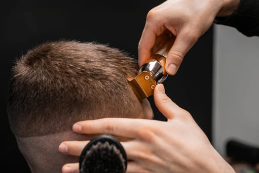 Close up barber shapes mans hair on the forehead