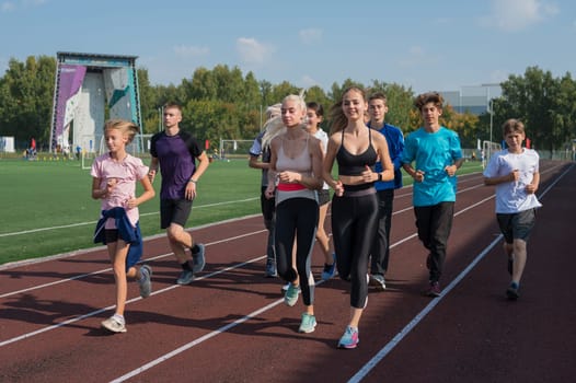 Group of young athletes training at the stadium. School gym trainings or athletics