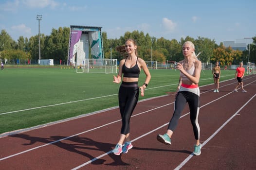 Group of young athletes training at the stadium. School gym trainings or athletics