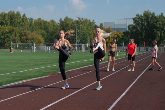 Group of young athletes training at the stadium. School gym trainings or athletics