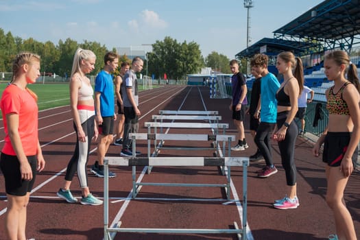 Group of young athletes training at the stadium. School gym trainings or athletics