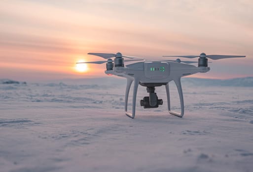 DJI Phantom 4 PRO drone on snow-covered lake baikal at sunset during winter.