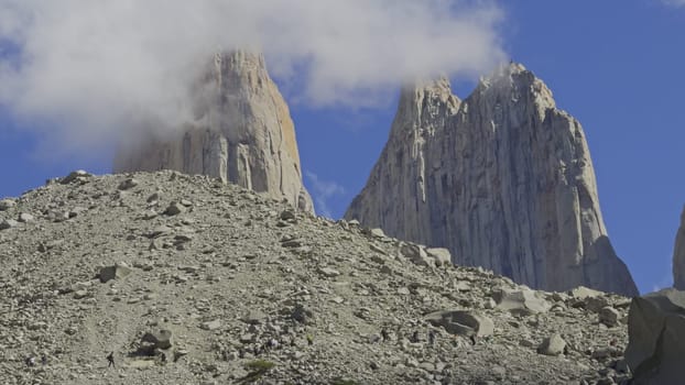 Hikers trek carefully through rough terrain aiming for the iconic Torres del Paine vista.