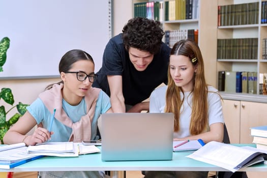 Group of high school students are studying in library class, classmates are laughing talking discussing together, team study project, preparing for tests and exams. Education adolescence communication