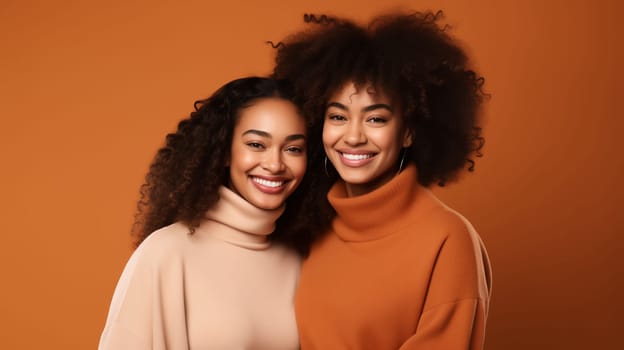 Portrait of happy smiling black mature mother and adult daughter, two african women together looking at camera on studio background