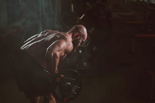 Caucasian bald topless man doing an exercise with a barbell in the gym