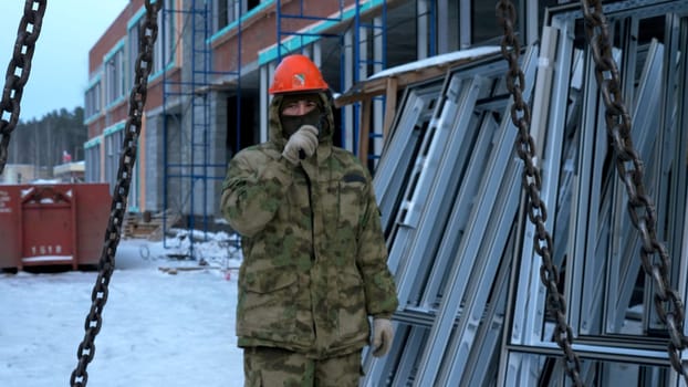 Transporting cement blocks by crane at the construction site. Clip. Builder and industrial background of a building