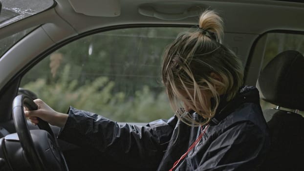 Young man with anxiety driving car. Stock. Close-up of man conveys emotions while driving car. Man with panic attack driving car on side of road.