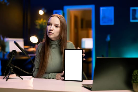 Teenager presenting mockup tablet in entry level low budget price range for tech enthusiasts. Gen Z influencer reviewing isolated screen digital device in front of internet subscribers