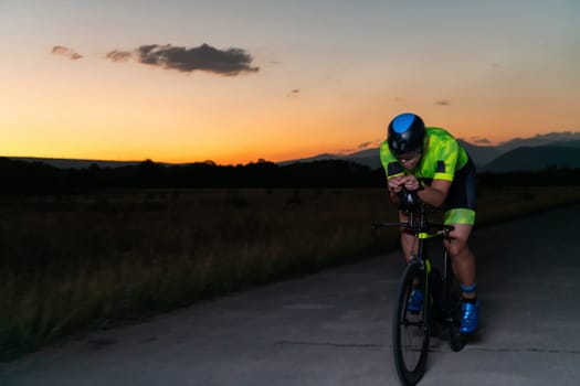 A triathlete rides his bike in the darkness of night, pushing himself to prepare for a marathon. The contrast between the darkness and the light of his bike creates a sense of drama and highlights the athlete's determination and perseverance