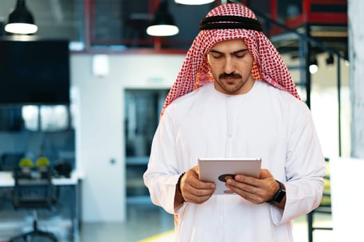 Arab muslim businessman using digital tablet in modern office close up