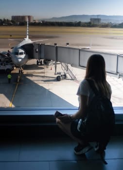 Young girl with her travel documents waiting for her plane to depart