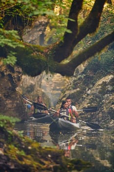 A group of friends enjoying having fun and kayaking while exploring the calm river, surrounding forest and large natural river canyons.