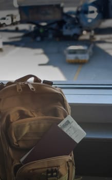 Backpack,ticket and passport next to an airport gate