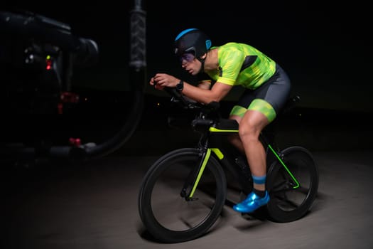 A videographer recording a triathlete riding his bike preparing for an upcoming marathon.Athlete's physical endurance and the dedication required to succeed in the sport