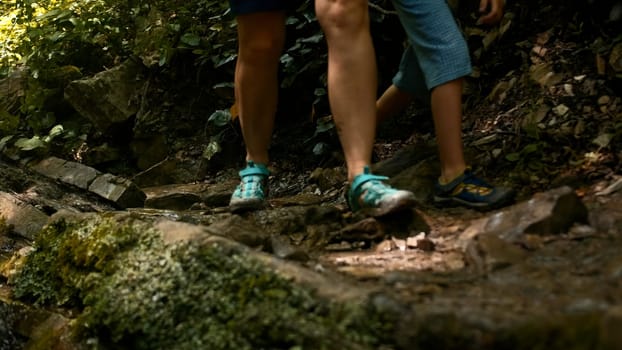 Female and child legs walk along a mountain road. Creative. Travel to the beautiful places of the world concept