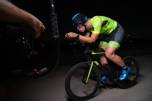 A videographer recording a triathlete riding his bike preparing for an upcoming marathon.Athlete's physical endurance and the dedication required to succeed in the sport