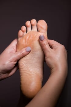 Close-up of a woman's foot massage. Vertical photo