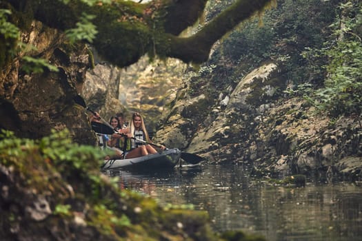 A group of friends enjoying having fun and kayaking while exploring the calm river, surrounding forest and large natural river canyons.