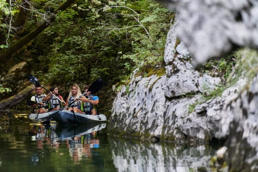 A young couple enjoying an idyllic kayak ride in the middle of a beautiful river surrounded by forest greenery.