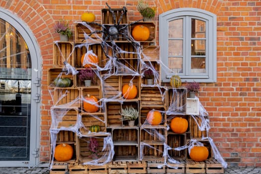 Exterior design cozy atmospheric halloween pumpkins in wooden boxes decorated on porch. Autumn leaves and fall flowers celebration holiday Thanksgiving October season outdoors in city