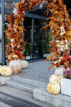 Exterior Beautiful cozy atmospheric halloween pumpkins decorated on porch. Autumn leaves and fall flowers celebration holiday Thanksgiving October season outdoors in city