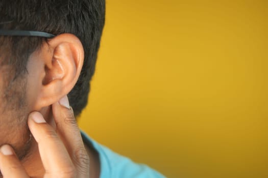 young man having ear pain touching his painful ear