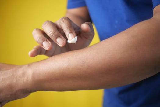 man applying moisturizing cream on hand .