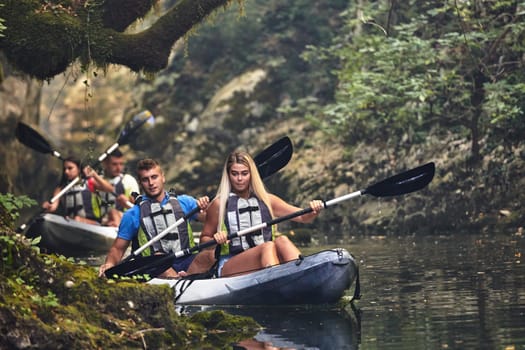 A group of friends enjoying having fun and kayaking while exploring the calm river, surrounding forest and large natural river canyons.