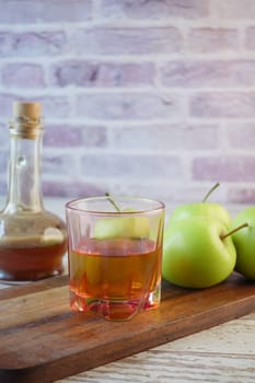 apple vinegar in glass bottle with fresh green apple on table ,