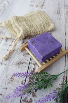 Homemade natural soap bar and lavender flower on table .