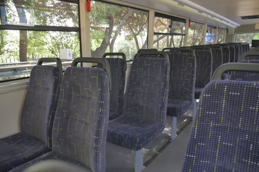 Blue seats inside of empty city bus