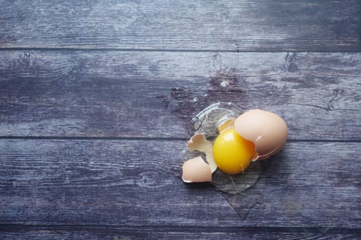 Fresh broken egg on wooden table .