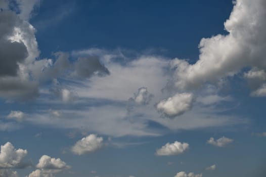 Clear blue sky with scattered fluffy white clouds, showcasing a tranquil and serene atmosphere.