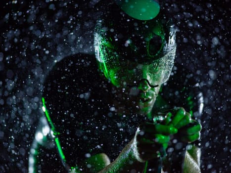 A triathlete braving the rain as he cycles through the night, preparing himself for the upcoming marathon. The blurred raindrops in the foreground and the dark, moody atmosphere in the background add to the sense of determination and grit shown by the athlete