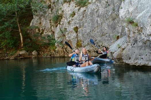 A group of friends enjoying having fun and kayaking while exploring the calm river, surrounding forest and large natural river canyons.