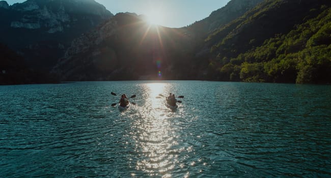 A group of friends enjoying fun and kayaking exploring the calm river, surrounding forest and large natural river canyons during an idyllic sunset