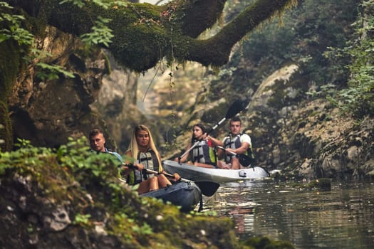 A group of friends enjoying having fun and kayaking while exploring the calm river, surrounding forest and large natural river canyons.