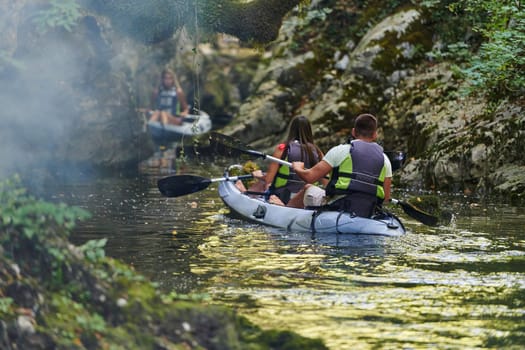 A group of friends enjoying having fun and kayaking while exploring the calm river, surrounding forest and large natural river canyons.