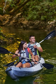 A young couple enjoying an idyllic kayak ride in the middle of a beautiful river surrounded by forest greenery.