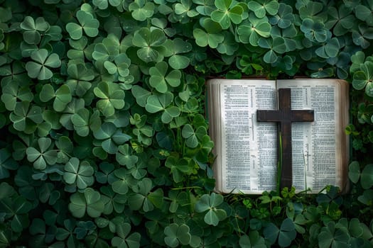 a bible book and a cross lying on the green clover leaves..