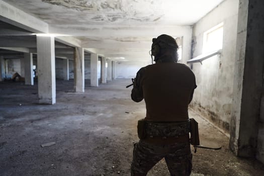 A professional soldier in an abandoned building shows courage and determination in a war campaign.