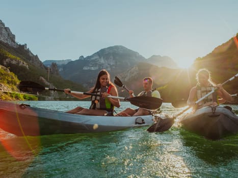 A group of friends enjoying fun and kayaking exploring the calm river, surrounding forest and large natural river canyons during an idyllic sunset