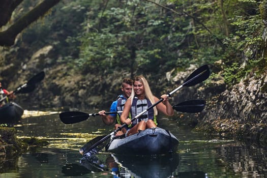 A group of friends enjoying having fun and kayaking while exploring the calm river, surrounding forest and large natural river canyons.