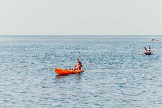Happy smiling woman in kayak on ocean, paddling with wooden oar. Calm sea water and horizon in background