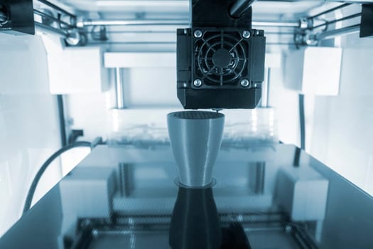3D printer working close-up. 3D printer prints model from molten plastic close-up. 3D printer printing object. Additive progressive high-tech technology. New modern prototyping technologies.