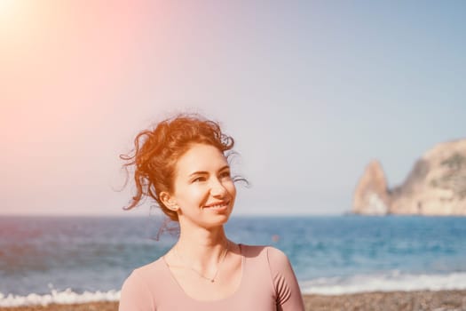 Middle aged well looking woman with black hair doing Pilates with the ring on the yoga mat near the sea on the pebble beach. Female fitness yoga concept. Healthy lifestyle, harmony and meditation.