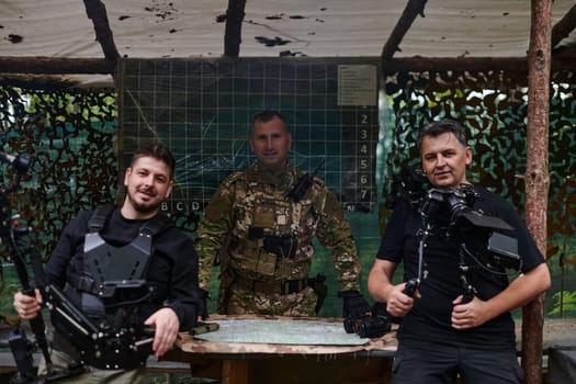 Two videographers collaborate seamlessly, capturing moments with a military major at his base, illustrating a harmonious blend of technology, media, and military communication in the production of a documentary or visual coverage.