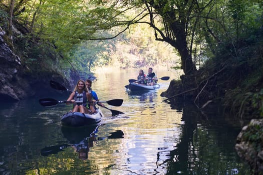 A group of friends enjoying having fun and kayaking while exploring the calm river, surrounding forest and large natural river canyons.