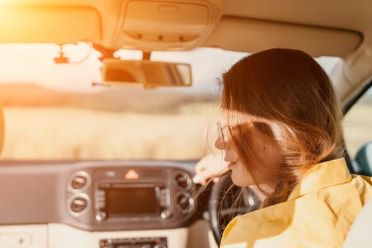 Relaxed business woman talking on video call on phone in automobile. Rested female professional saying bye on video chat in business car. Beautiful lady making video message in luxury car.